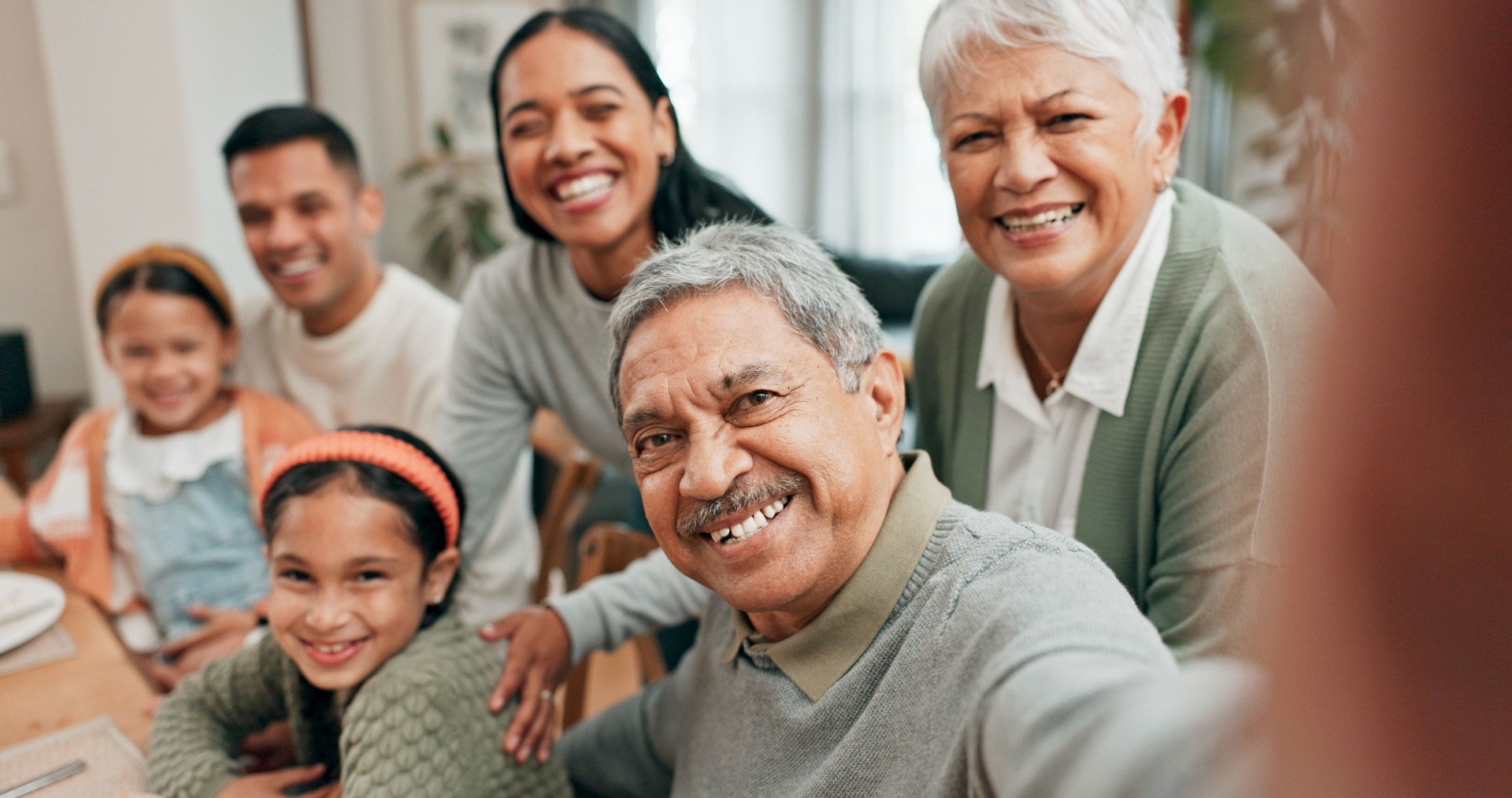 Family, home and smile with selfie for lunch in table for memories, profile picture and social media. People, generations and parents with kids on portrait for love, support and care for thanksgiving